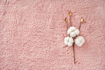 Branch cotton on pink towel texture background with copy space. Nature background. Flat lay, top view of cotton. Natural textile.