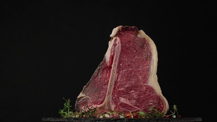 Wall Mural - T bone. Raw beef steak. Presentation of the dish. Rotation. Black background.