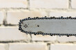 Chain on a old chainsaw tire close-up on the background of a light brick wall
