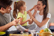 A young family having a good time while having a breakfast at home together. Family, breakfast, playing, togetherness