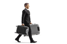 Full Length Profile Shot Of A Businessman In A Suit Walking And Carrying Suitcases
