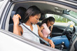 © Louis-Photo - Young black teenage driver seated in her new car with her mother