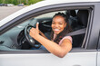 © Louis-Photo - Young black teenage driver seated in her new car
