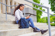 © Louis-Photo - cute black teenager university student on campus with backpack and cellphone