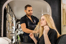 Stylist Consults With Young Woman Before Hair Appointment At Boutique Salon