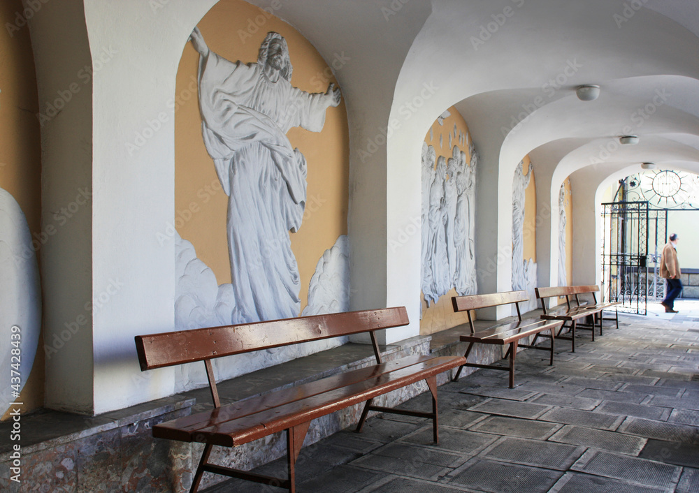 NOWY SACZ, POLAND - MAY 28, 2021: A monastery corridor decorated with reliefs of saints - obrazy, fototapety, plakaty 