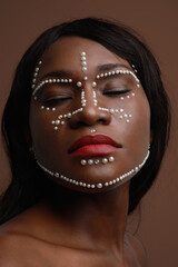 Sticker - Close-up portrait of attractive black woman with pearls on her face. Vertical.