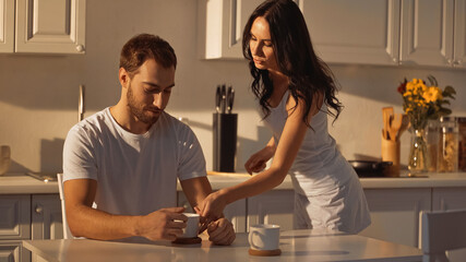 Wall Mural - brunette woman serving cup of coffee to boyfriend