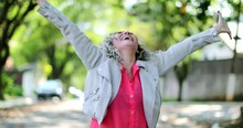 Ecstatic woman jumping with joy celebrating success outside in street
