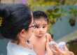 © nilanka - Innocent baby girl looking at the camera, beautiful eyes and black haired south Asian baby girl in mothers arms.