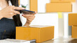 © ArLawKa - Asian businesswoman owning SME online using laptop and mobile phone. Receive customer orders with parcel boxes at her home office. online business ideas