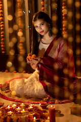 Portrait of an Indian woman holding flowers on a festive occasion. Celebrations at home. Diwali or Christmas.