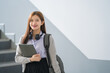© EduLife Photos - Portrait of a young Asian woman student in uniform holding tablet in smart and happy pose in university or college classroom. Youth girl student and tutoring education with technology learning concept