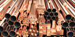 Copper tubes and different profiles in warehouse background. Different copper metal rolled products.