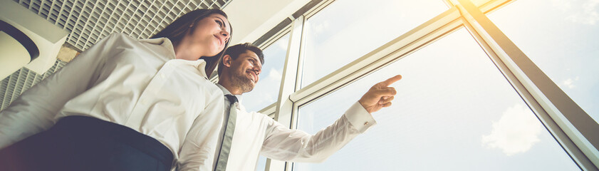 Wall Mural - The business man and woman stand near the window and gesture