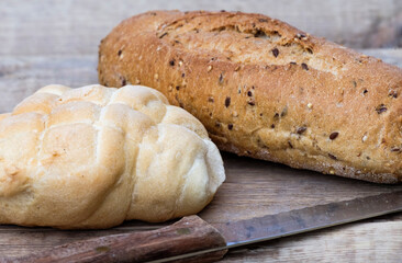 Due pagnotte di pane con coltello, pane naturale su sfondo di legno adatto per contenuti sui ristorante