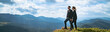 © realstock1 - The happy couple standing on the mountain with a picturesque cloudscape