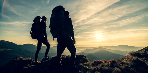 Wall Mural - the couple standing on a mountain with a picturesque sunrise background