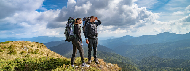 Wall Mural - the couple on the mountain on the picturesque cloudscape background