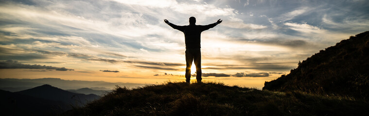 Wall Mural - the happy man standing on the rock with the picturesque sunrise
