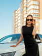Modern beautiful woman businesswoman stands near her car. 