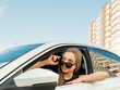 Modern beautiful woman businesswoman with glasses peeks out of her car.