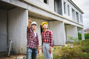 Two Civil Engineers, field engineers, foreman, owner's standing in the construction site project in the background.