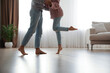 © New Africa - Couple dancing barefoot in living room, closeup. Floor heating system