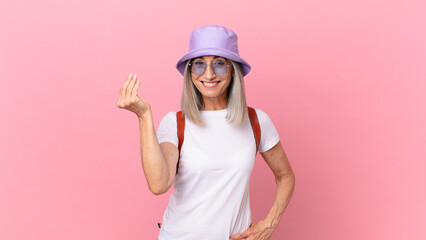 Wall Mural - middle age white hair woman making capice or money gesture, telling you to pay. summer concept