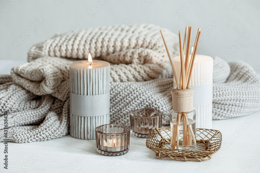 Cozy home composition with candles, aroma sticks and a knitted element. - obrazy, fototapety, plakaty 