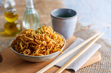 Japanese food , vegetable noodles in Teriyaki sauce served in a bowl with chopsticks on the side.