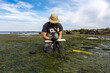 Scientist collecting a sediment core to asses carbon sequestration rates in the sediment of a tidal seagrass bed.