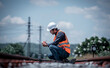 © APchanel - Engineer under  inspection and checking construction process railway switch and checking work on railroad station .Engineer wearing safety uniform and safety helmet in work.
