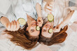 © Daria Lukoiko - Two girls make homemade face and hair beauty masks. Cucumbers for the freshness of the skin around the eyes. Women take care of youthful skin. Girlfriends laugh at home lying on the floor on pillows.