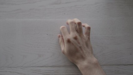 Canvas Print - POV shot of man finger tap on white oak table with window light