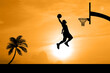 Basketball players jumping dunk silhouettes on a beautiful outdoor basketball court in the evening.