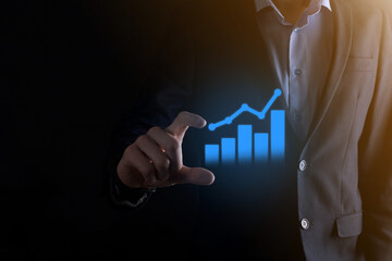 Businessman man holding a graph with positive profits growth. plan graph growth and increase of chart positive indicators in his business.more profitable and growing.