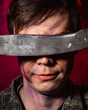 © ISliM - A close-up portrait of a soldier in scars and a battle coloring wielding a machete in front of his eyes