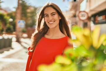 Wall Mural - Young hispanic woman smiling happy standing at the city.