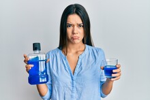 Young Hispanic Girl Holding Mouthwash For Fresh Breath Depressed And Worry For Distress, Crying Angry And Afraid. Sad Expression.