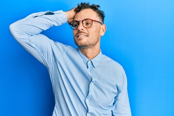 Young hispanic man wearing casual clothes and glasses smiling confident touching hair with hand up gesture, posing attractive and fashionable