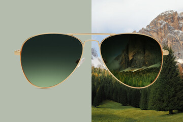 Wall Mural - aviator sunglasses isolated on green and winter background with snow on the mountain tops, concept of polarized protective lenses