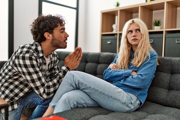 Poster - man asking for forgiveness to his girlfriend at home.