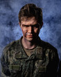 © ISliM - Portrait of a close-up of a soldier in scars and battle paint against the background of smoke