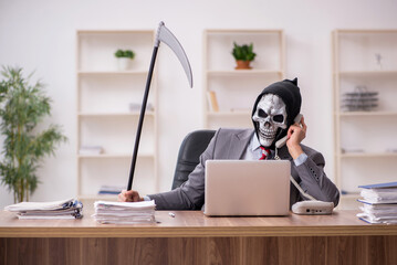 Wall Mural - Devil businessman employee sitting at workplace