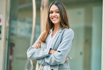 Young latin businesswoman with crossed arms smiling happy at the city.