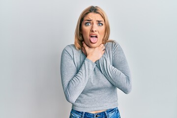 Young caucasian woman wearing casual clothes shouting and suffocate because painful strangle. health problem. asphyxiate and suicide concept.