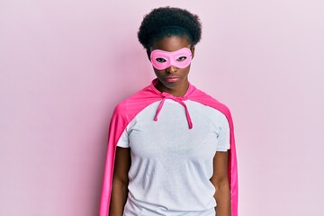 Wall Mural - Young african american girl wearing superhero mask and cape costume depressed and worry for distress, crying angry and afraid. sad expression.