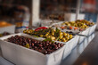 Freshly pickled olives on a market. Mediterranean vegetables in olive oil. Food photography with short depth of field.