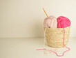 pink and soft pastel woolen balls in basket with crochet hook and space for text